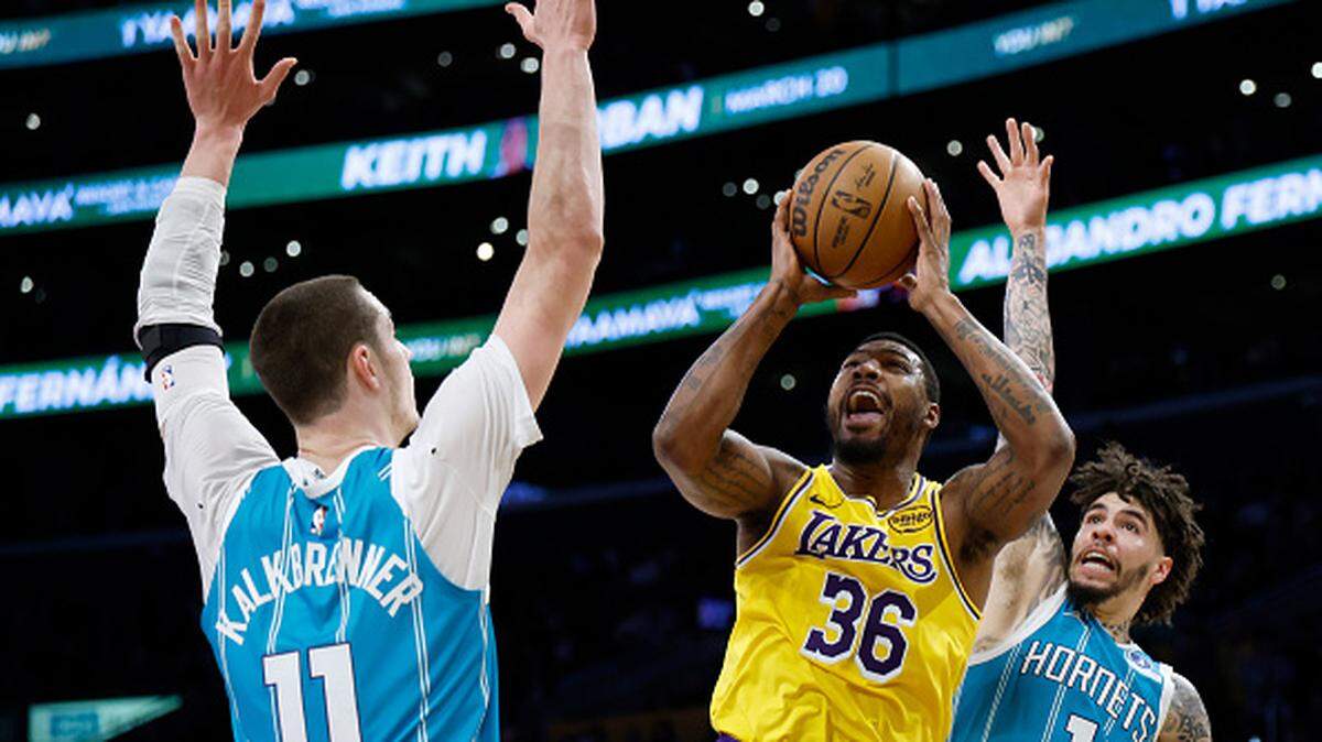Marcus Smart of the Los Angeles Lakers reacts as he is fouled by LaMelo Ball of the Charlotte Hornets in front of Ryan Kalkbrenner during the first half at Crypto.com Arena.