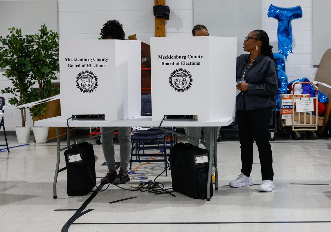 Poll worker Tracy Wilson, right, instructs a voter on how to cast their ballot at Ebenezer Baptist Church on election day in Charlotte, NC on Tuesday, November 5, 2024.