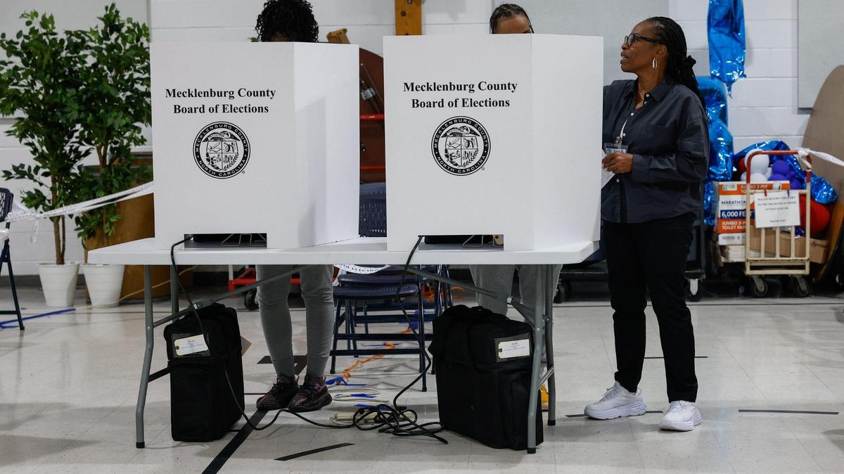 Poll worker Tracy Wilson, right, instructs a voter on how to cast their ballot at Ebenezer Baptist Church on election day in Charlotte, NC on Tuesday, November 5, 2024.