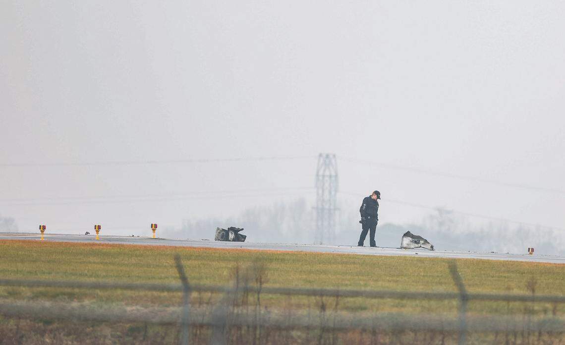 An officer inspects part of a plane at Statesville Regional Airport on Thursday morning, Dec. 18, 2025. NASCAR driver Greg Biffle was one of seven people killed on the plane.