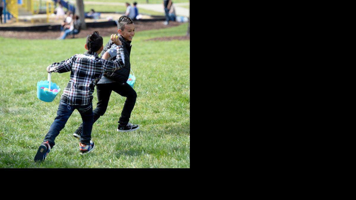 
Kevin Medina-Ramirez, left, chases his brother, Luis, with a confetti-filled egg during a family Easter egg hunt near Belle Johnston Park in Pineville on Sunday, April 5, 2015. 
