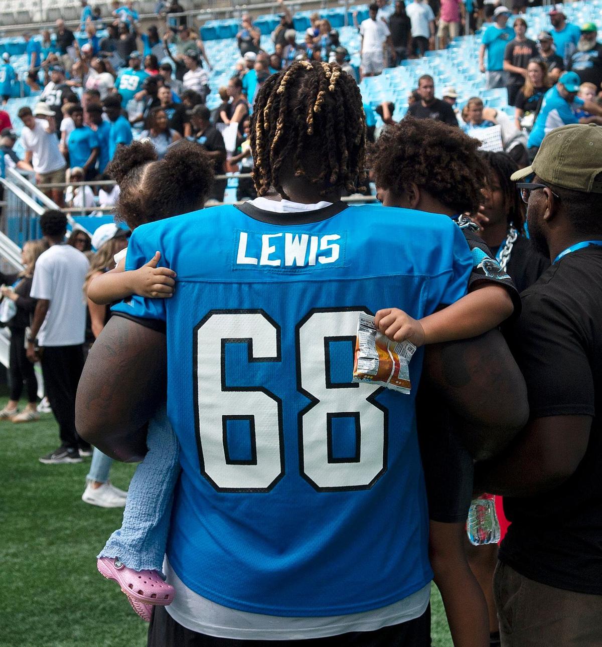 #68, Damien Lewis cradled a pair of youngsters after practice Saturday. Fans celebrated the return of Panthers’ football during practice at Bank of America Stadium on Saturday, July 27, 2024 as part of the annual Back Together Saturday event. Practice, which began at 9:30 a.m., included performances by the Panthers entertainment group and activities for fans. Fans cheered on players like Bryce Young (#9), Xavier Legette (#17), Damien Lewis (#68) and head coach Dave Canales.