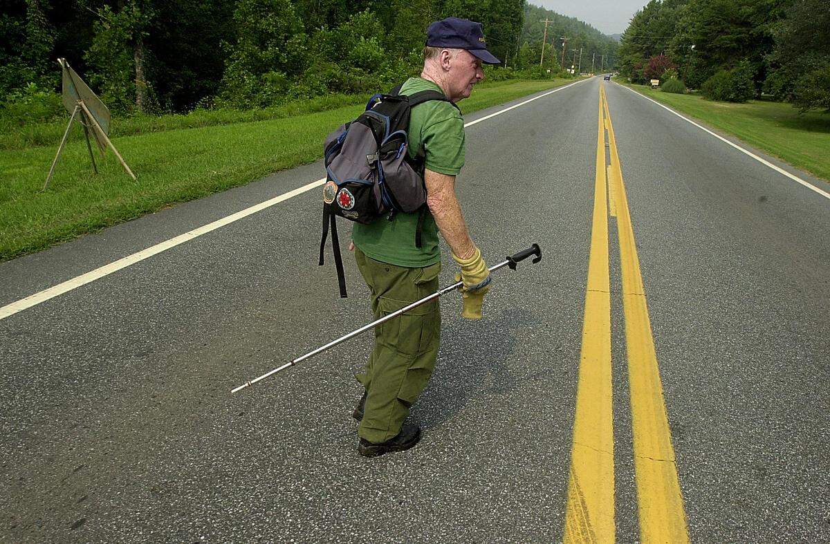 Bill Reddick, from McDowell Rescue, makes his way across N.C. 18 during a search for Asha Degree, 9, Wednesday morning, Aug. 15, 2001.