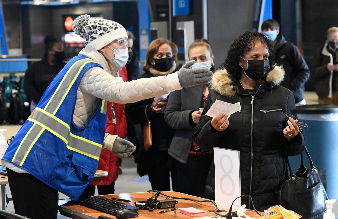 Terrie Payne is directed to the next station as she is processed at the Bank of America Stadium Atrium Health vaccine clinic on Friday, January 29, 2021. Atrium Health, Honeywell, Tepper Sports & Entertainment and Charlotte Motor Speedway formed a public-private partnership that expects to vaccinate 19,000 people at the Friday through Sunday event.