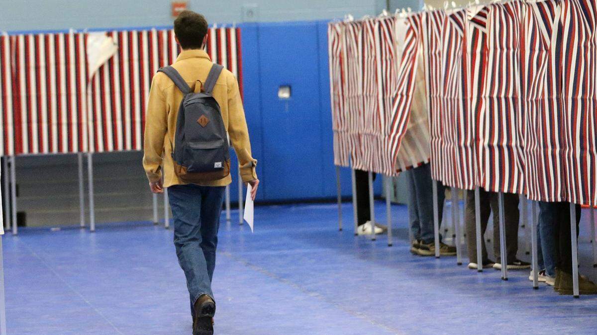 A young voter walks to an open booth to cast his ballot in the New Hampshire primary in Durham, NH on Jan. 23, 2024.