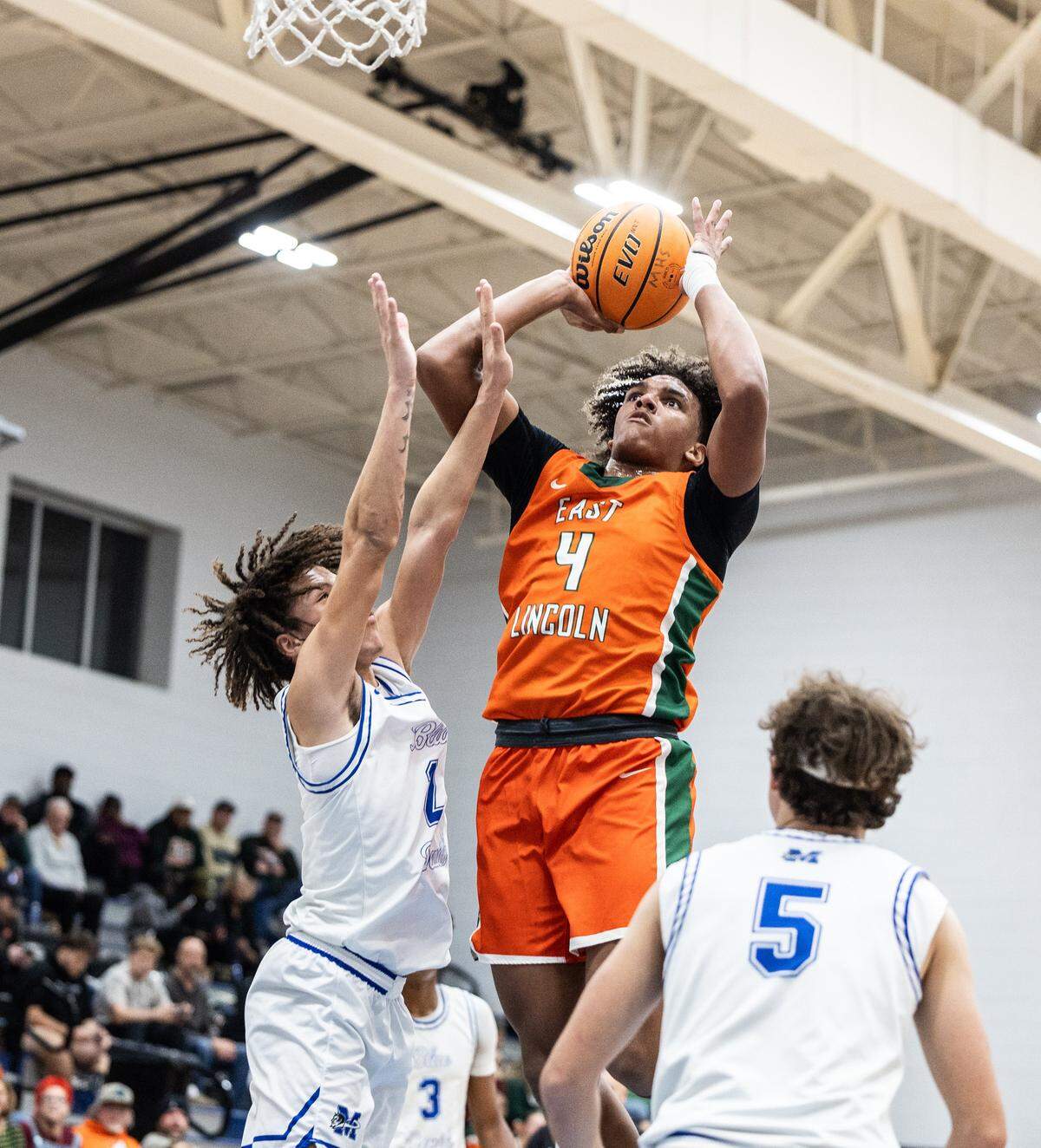 East Lincoln Mustangs Jaxon Dollar, right, shoots past a block by Maiden Blue Devils Javien Seagle at Maiden High School in Maiden, N.C., on Monday, January 12, 2025.