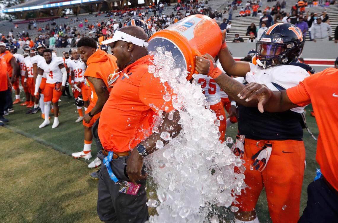 Vance head coach Glenwood Ferebee is doused with ice water in the final seconds of Vance High School’s 35-14 victory over Rolesville High School in the NCHSAA 4AA state championship at Carter-Finley Stadium in Raleigh, N.C., Saturday, May 8, 2021.