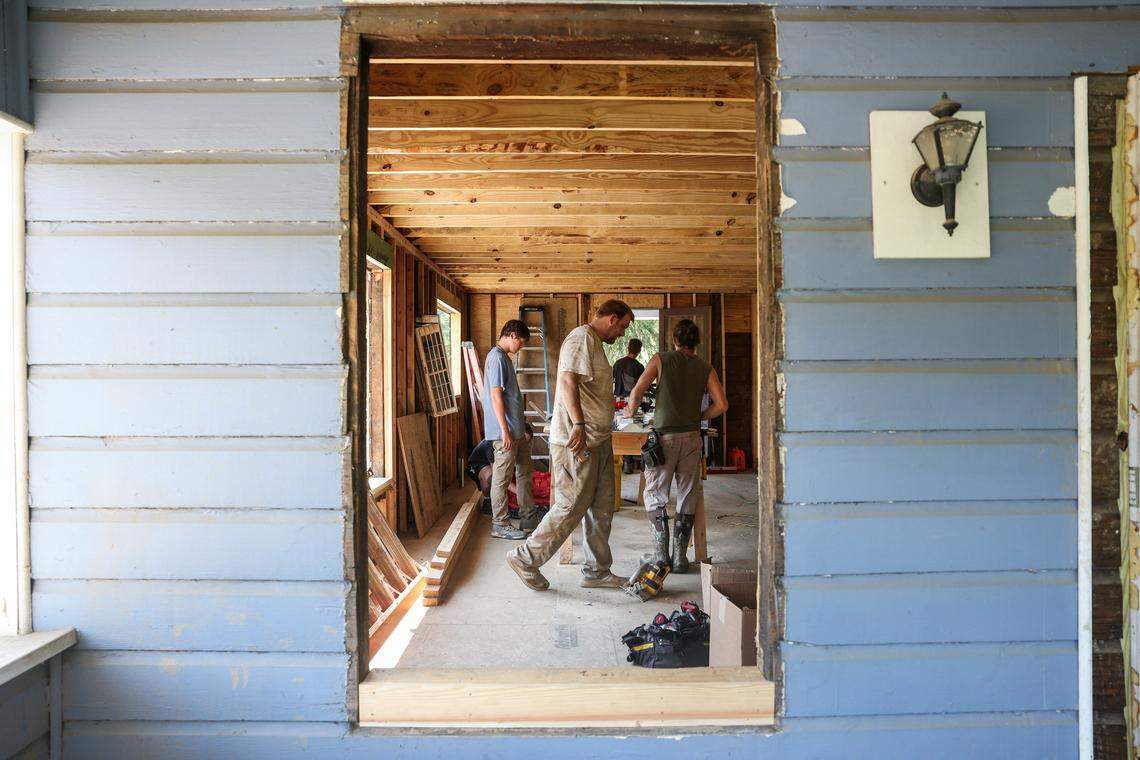 Workers with Every Angle, Inc., an integrative construction company based in Marshall, NC work on restoring the framework and flooring of a house located on Carolina Lane, in downtown.