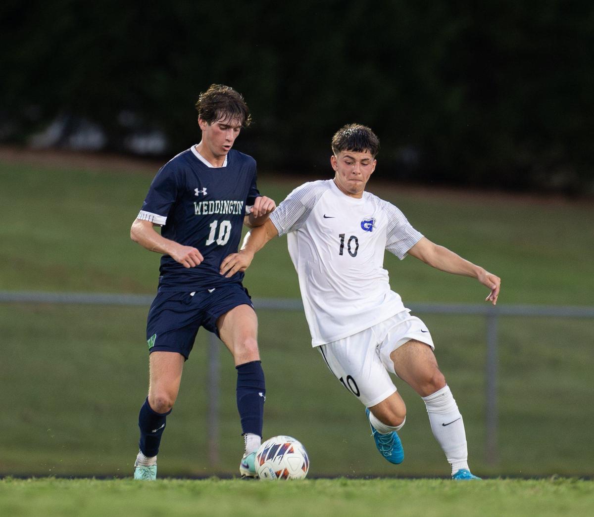 Weddington Warriors Pierce Cooper, left, and Garinger Wildcats Diego Silva fight for control of the ball at Weddington High School in Matthews, N.C., on Wednesday, August 28, 2024.
