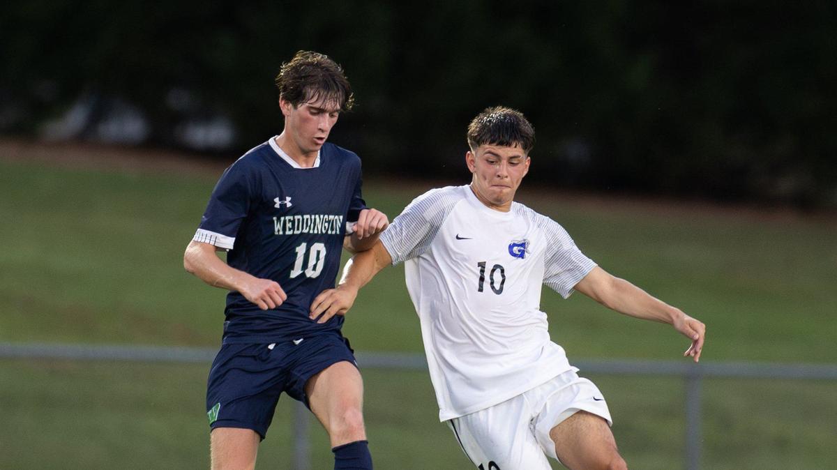 Weddington Warriors Pierce Cooper, left, and Garinger Wildcats Diego Silva fight for control of the ball at Weddington High School in Matthews, N.C., on Wednesday, August 28, 2024.