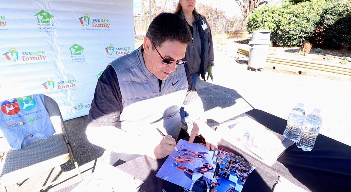 Ron Rivera signs a photo from a CharlotteFive interview in September. The Humane Society of Charlotte and Ron and Stephanie Rivera hosted a yard sale on Saturday, Feb. 15, with the proceeds going toward the Humane Society’s capital campaign to build a new facility.
