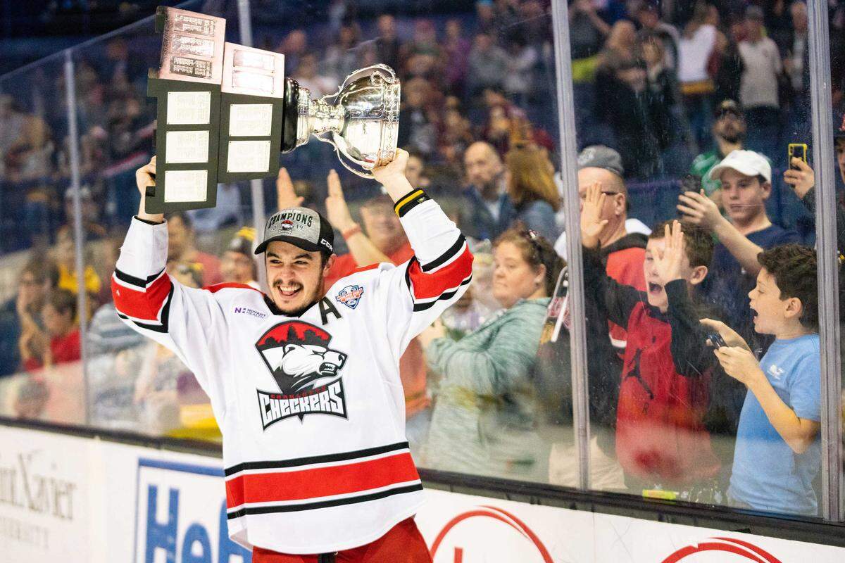 Charlotte Checkers forward Andrew Poturalski shows off the hardware to the fans at Allstate Arena after the team’s Calder Cup-clinching victory over Chicago Wolves in Game 5 of the series in Rosemont, Ill., on Saturday. It’s the first championship for the Checkers after nine seasons in the league. Poturalski was named the most valuable player for the AHL playoffs.
