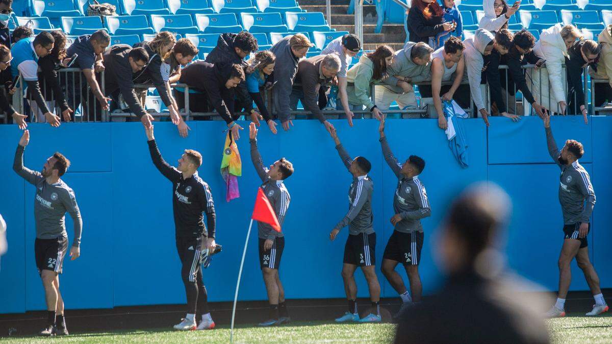 Charlotte Football Club players slap hands with fans after an open training session at Bank of America Stadium on Thursday, February 10, 2022 in Charlotte, NC.