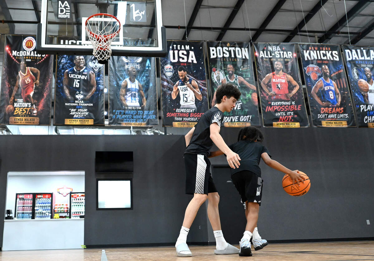 Banners depicting former Charlotte Hornets guard Kemba Walker’s career serve as a backdrop as Jake Rella, 15, and Alex Postman, 10, play basketball at the Kemba Walker Sports Academy in Concord, North Carolina, on Friday, June 26, 2026.