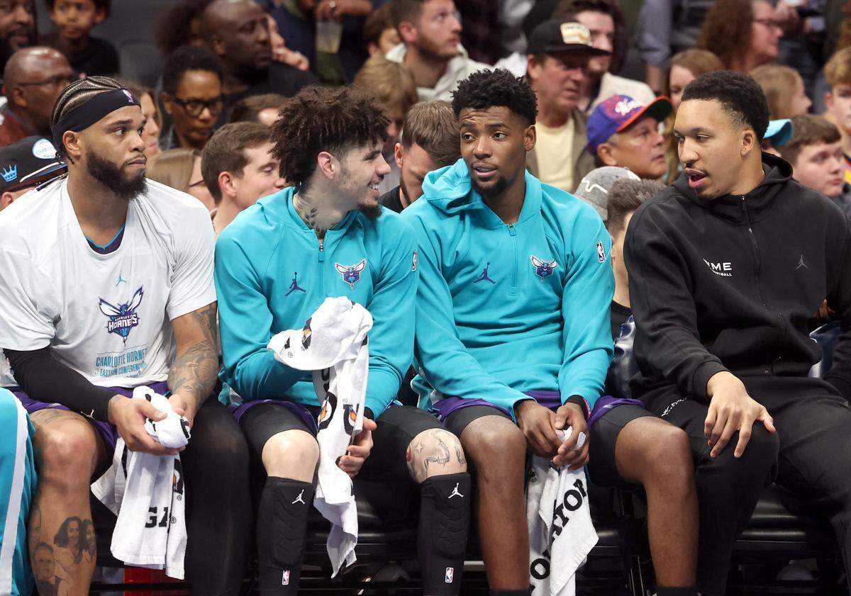 Charlotte Hornets forward Miles Bridges, left, guard LaMelo Ball, guard Brandon Miller and Grant Williams sit on the team’s bench during action against the New York Knicks at Spectrum Center in Charlotte, North Carolina, on Wednesday, Nov. 26, 2025.