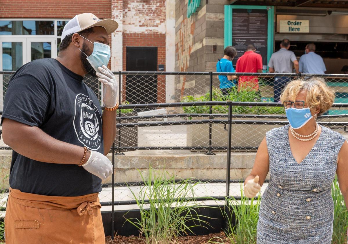 Chef Greg Collier and Mayor Vi Lyles share a moment before the ribbon-cutting at Camp North End’s new Keswick Avenue Food Stalls and unveiling of the rare Gama Goat.