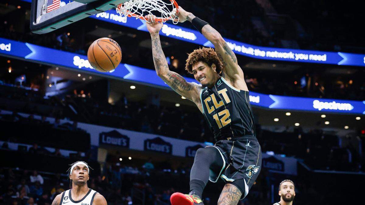 Charlotte Hornets guard Kelly Oubre Jr. (12) slam dunks the ball over Minnesota Timberwolves forward Jaden McDaniels (3) and Minnesota Timberwolves center Rudy Gobert (27) during a game at Spectrum Center in Charlotte, N.C., Friday, Nov. 25, 2022.