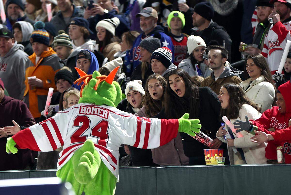 Charlotte Knights mascot Homer the Dragon runs down the first base line slapping hands with fans prior to the Charlotte Checkers battling the Rochester Americans in the 2024 Queen City Outdoor Classic at Truist Field in uptown Charlotte, NC on Saturday, January 13, 2024.
