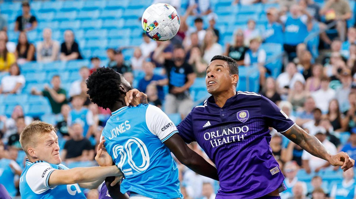 Charlotte FC midfielder Derrick Jones (20) and forward Karol Swiderski, left, battles Orlando City defender Antônio Carlos for the ball in the first half in Charlotte, N.C., Sunday, Aug. 21, 2022.