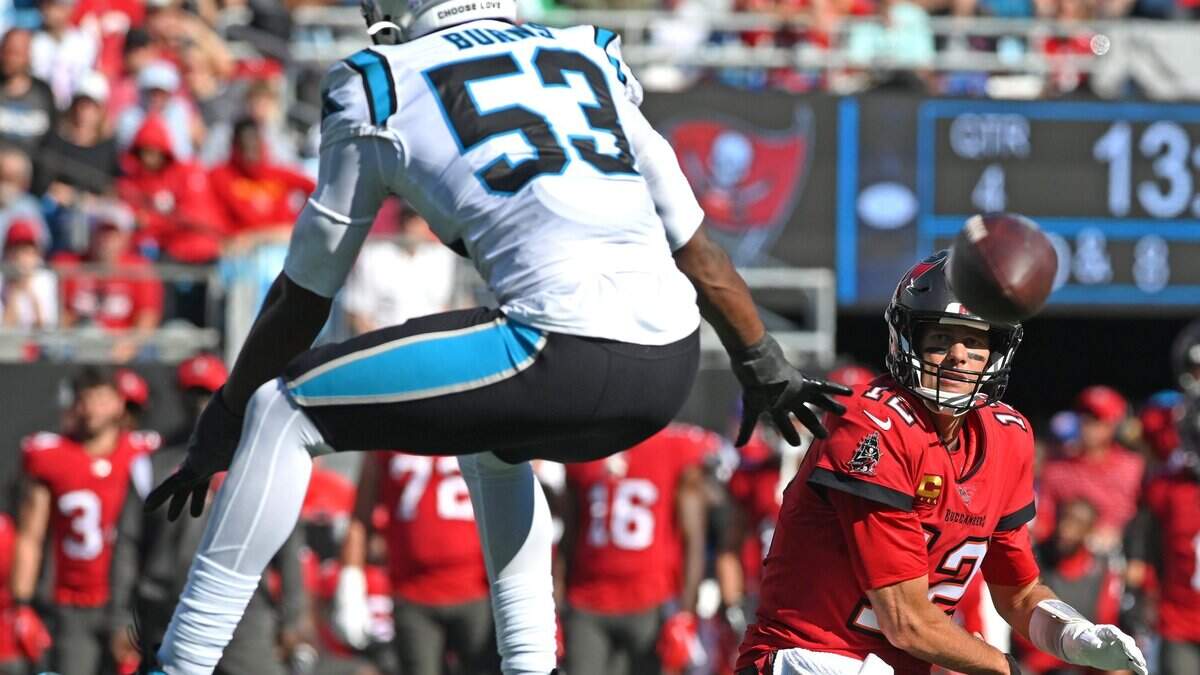 Carolina Panthers defensive end Brian Burns, left, leaps into the air to disrupt Tampa Bay Buccaneers quarterback Tom Brady on a pass attempt during second half action at Bank of America Stadium in Charlotte, NC on Sunday, October 23, 2022. The Panthers defeated the Buccaneers 21-3.