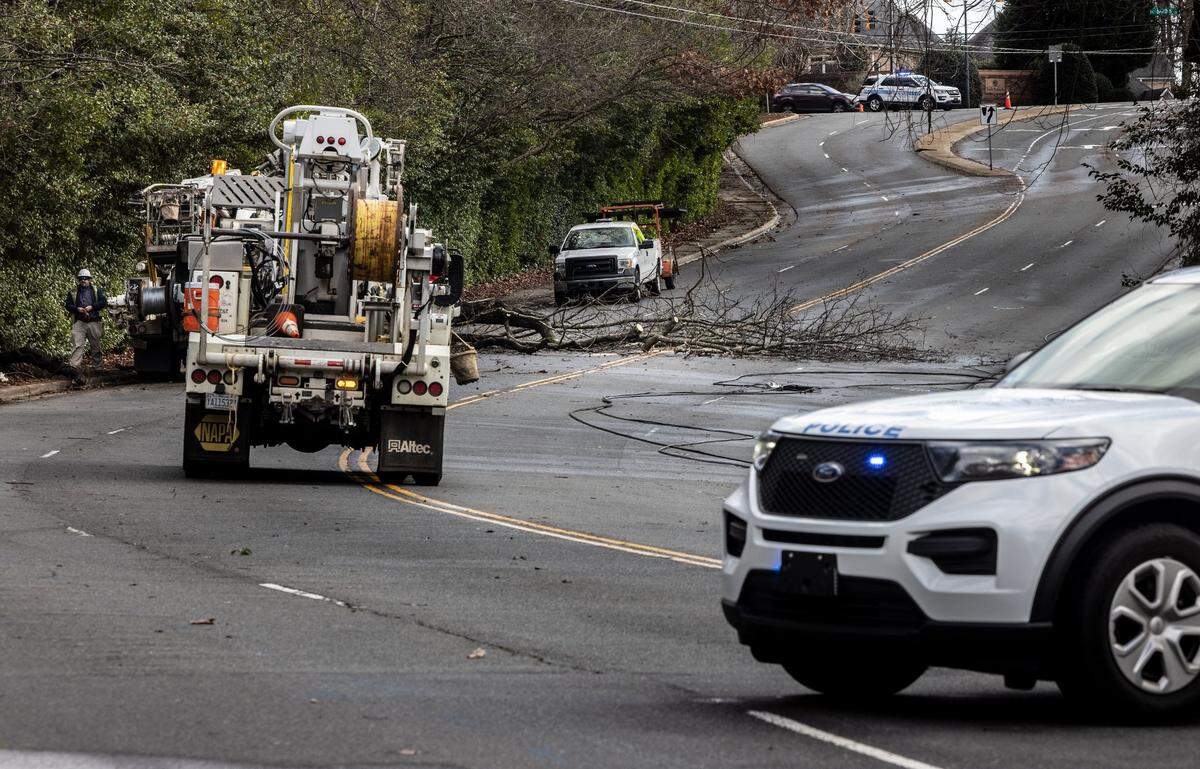 A crew works on repairing downed power lines on Randolph Road in Charlotte, N.C., on Monday, January 3, 2022.