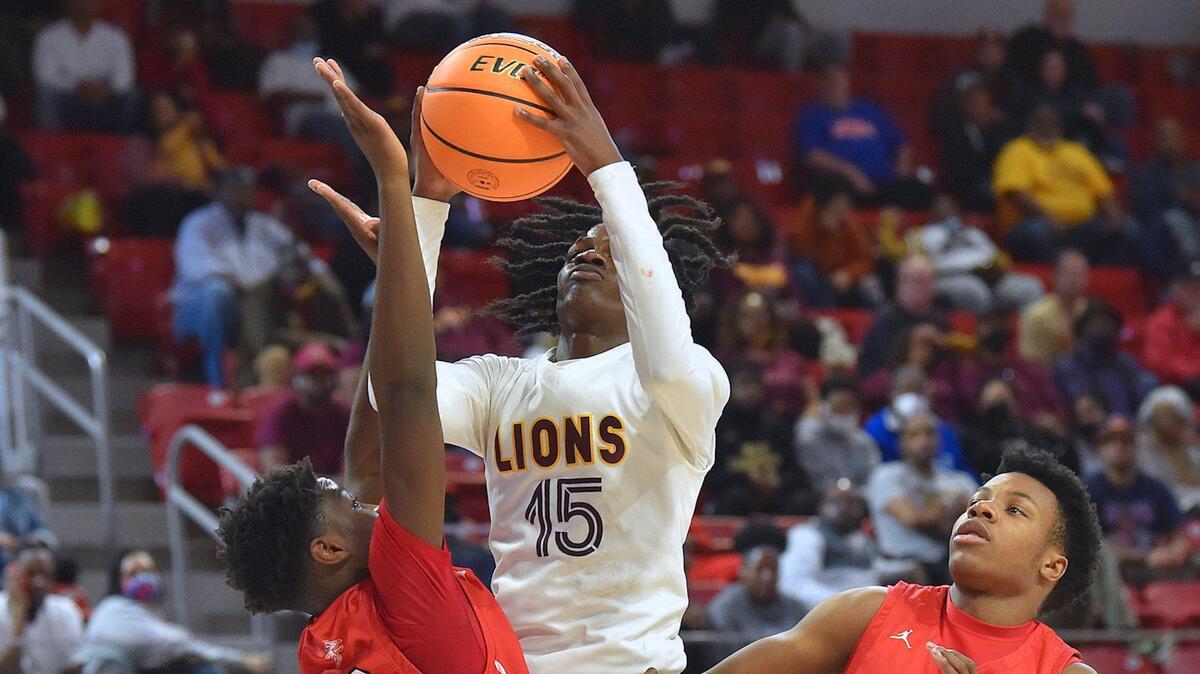 West Charlotte’s Josh Mahatta (15) shoots the ball between Seventy-First’s Deandre Nance (30) and Waylon Robinson (33). The West Charlotte Lions and the Fayetteville Seventy-First Falcons met in the NCHSAA Boys Basketball 3A Championship Game in Raleigh, N.C. on March 12, 2022.