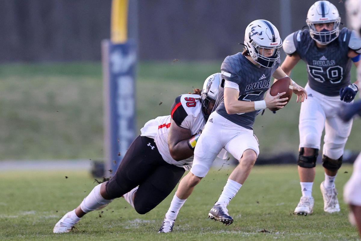 Hickory Ridge quarterback Alex Bentley carries the football as Butler defender Bryce Dixon makes the tackle in the first half at Hickory Ridge high school on Friday, March 26, 2021.