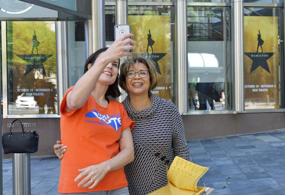 Kate Fellman, left, takes a selfie with Charlotte mayor Vi Lyles during a voter registration drive in front of the Belk Theater Friday. Some members of the cast of the Broadway smash "Hamilton," and Mayor Vi Lyles held a voter registration drive in front of Belk Theater on the final day to register to vote in NC. Blumenthal Performing Arts teamed up with the non-partisan voter education organization You Can Vote to help register and educate voters. Hamilton opened Wednesday and will be in town through Nov. 4.