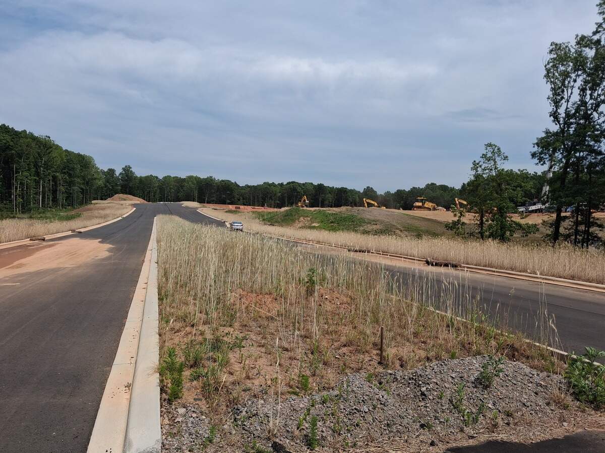 Work is 75% complete on the first phase of the four-lane East West Connector highway in Mooresville near Lake Norman, a town official said Tuesday. At far right, workers use heavy equipment to grade land along the highway for a Lowes Foods grocery store.
