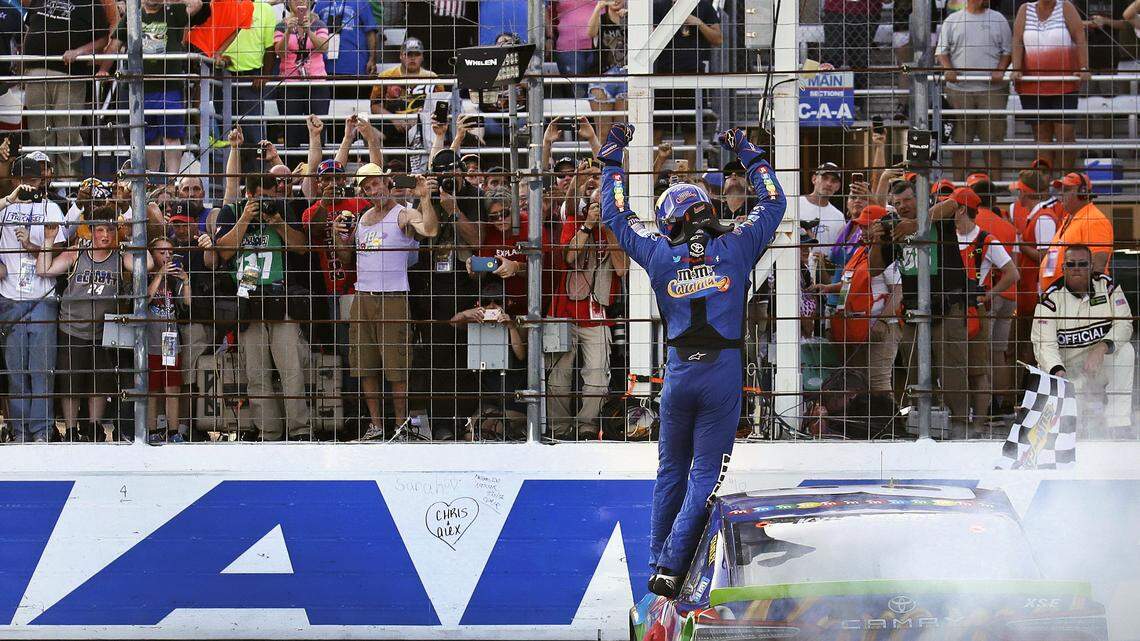 FILE - In this Sept. 24, 2017, file photo, Kyle Busch raises his arms towards fans after winning the NASCAR Cup Series 300 auto race at New Hampshire Motor Speedway in Loudon, N.H. The photo was part of a series of images by photographer Charles Krupa which won the Thomas V. diLustro best portfolio award for 2017 given out by the Associated Press Sports Editors during their annual winter meeting in St. Petersburg, Fla. (AP Photo/Charles Krupa, File)