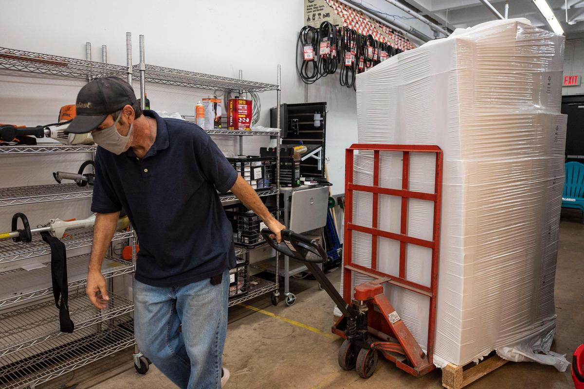 Patrick Chalk pulls a palette of boxes filled with Christmas decorations on Friday morning at Blackhawk Hardware in Park Road Shopping Center in Charlotte.