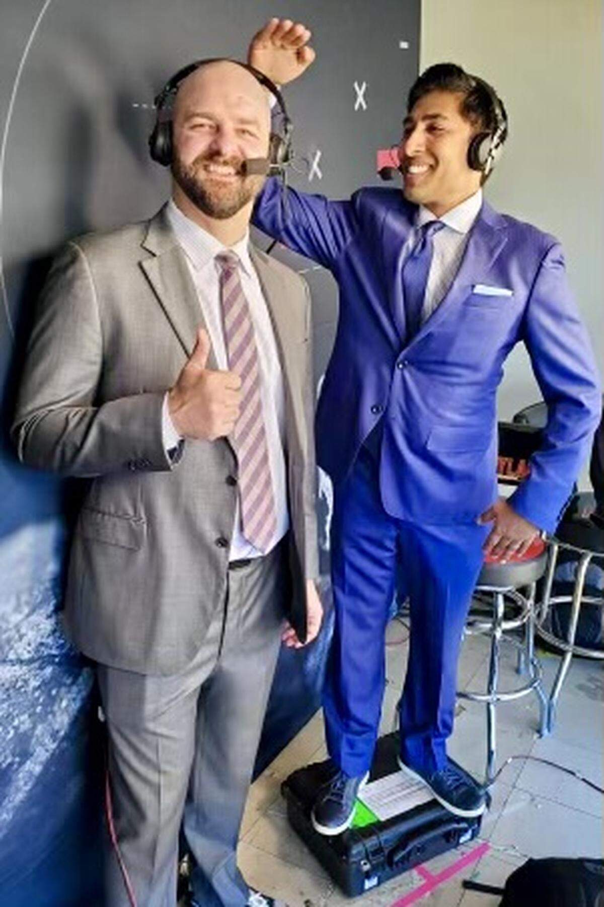 Anish Shroff (right) measures his height against broadcasting partner Mike Golic Jr. before an ESPN game in 2021. Shroff will become the Carolina Panthers’ new radio play-by-play announcer in 2022.