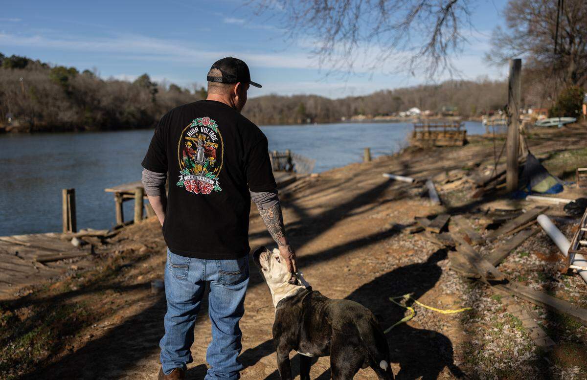 Donnie McGuire, photographed in the backyard of his childhood home with his dog Cash. He hopes to stay. “Once you live here, it’s hard to get away from.”