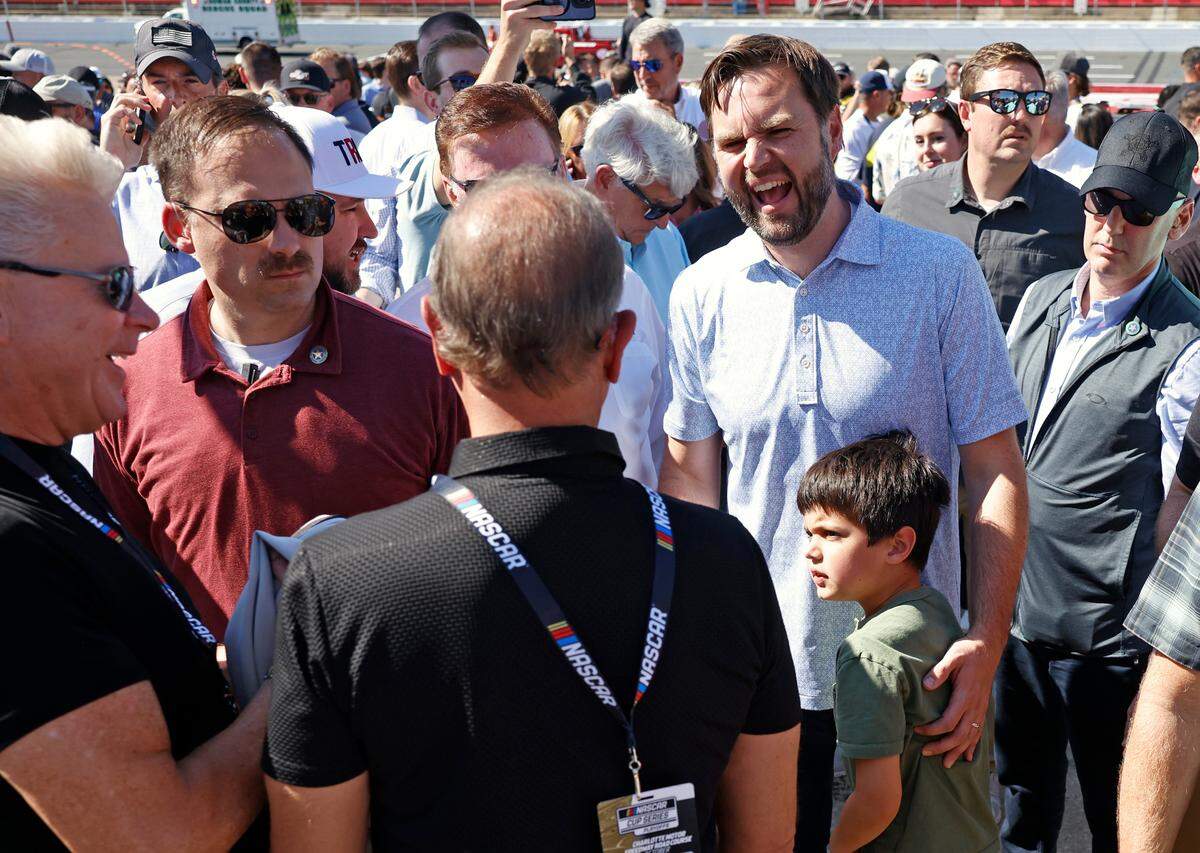 Vice Presidential Nominee Senator JD Vance, right, laughs as he talks with people along pit road at Charlotte Motor Speedway prior to the running of the Bank of America Roval 400 on Sunday, October 13, 2024 in Concord, NC.