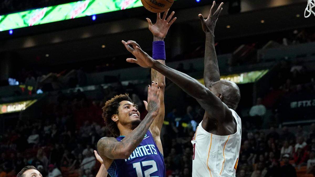 Charlotte Hornets guard Kelly Oubre Jr. (12) drives to the basket as Miami Heat center Dewayne Dedmon (21) defends during the first half of an NBA basketball game Thursday, Nov. 10, 2022, in Miami. (AP Photo/Marta Lavandier)