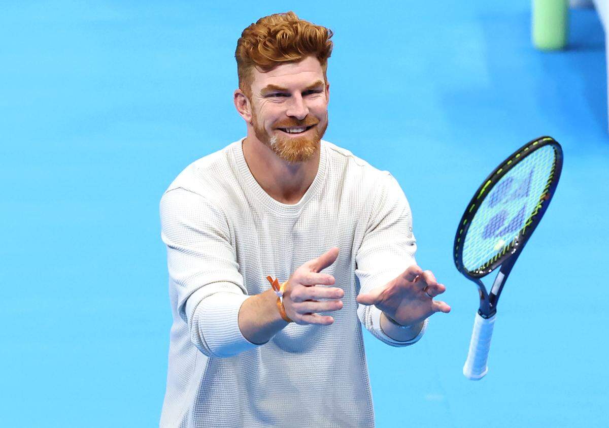 Carolina Panthers quarterback Andy Dalton reaches out to catch a tennis racket to hit some balls during the Taylor Fritz vs. Frances Tiafoe match in the Charlotte Invitational on Thursday in Charlotte.