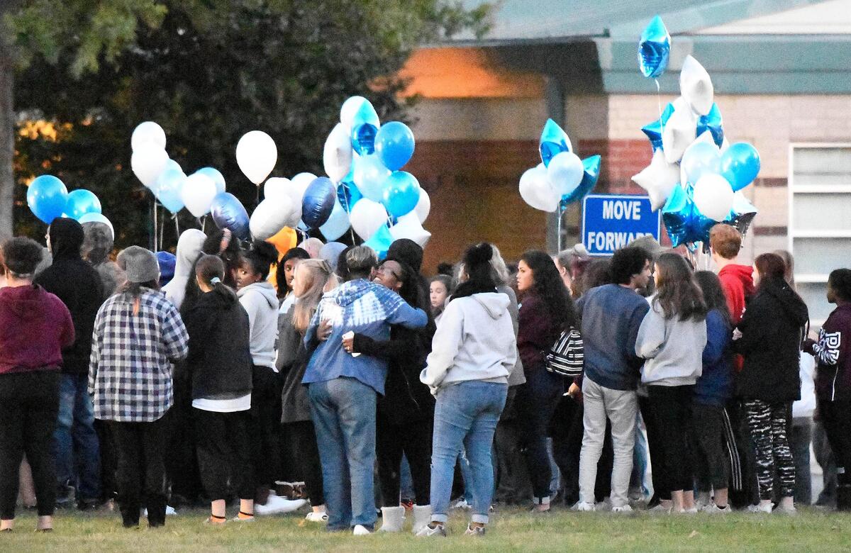 Students greet one another at the start of Monday night’s vigil at Butler High School in Matthews.