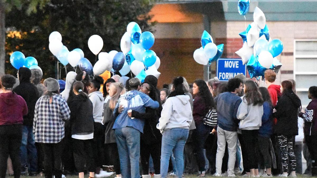 Students greet one another at the start of Monday night’s vigil at Butler High School in Matthews.