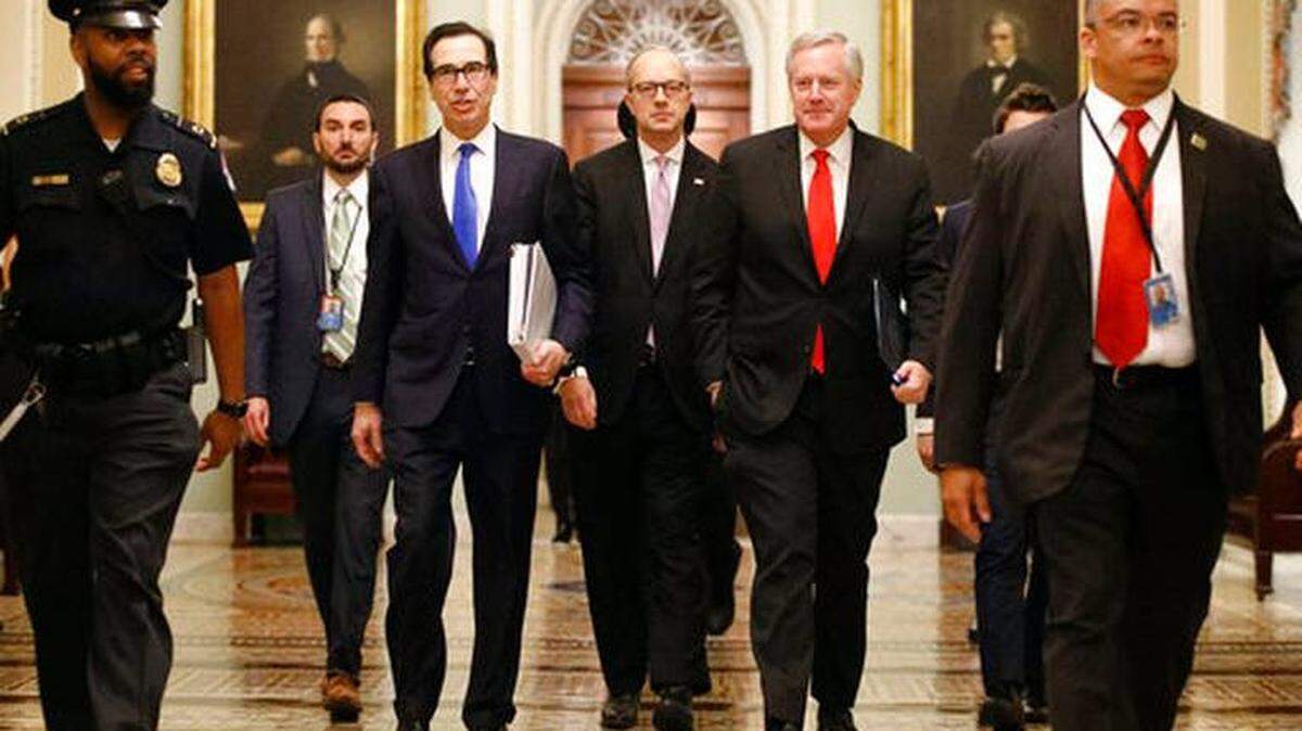 Treasury Secretary Steven Mnuchin, left, White House Legislative Affairs Director Eric Ueland and acting House chief of staff Mark Meadows walk to Senate Majority Leader Mitch McConnell’s office Tuesday amid negotiations over the coronavirus relief bill.