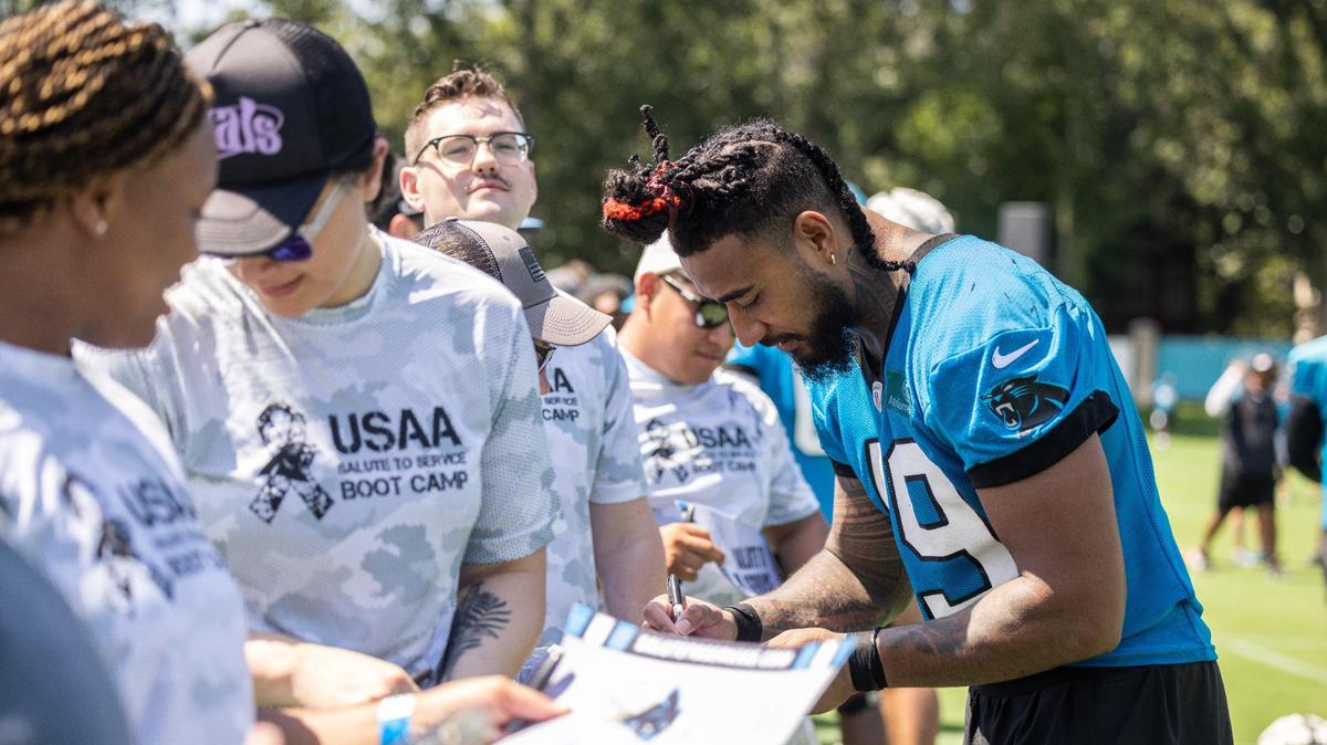 Carolina Panthers players sign autographs during USAA’s Salute to Service NFL Boot Camp in Charlotte, N.C., on Monday, August 14, 2023.