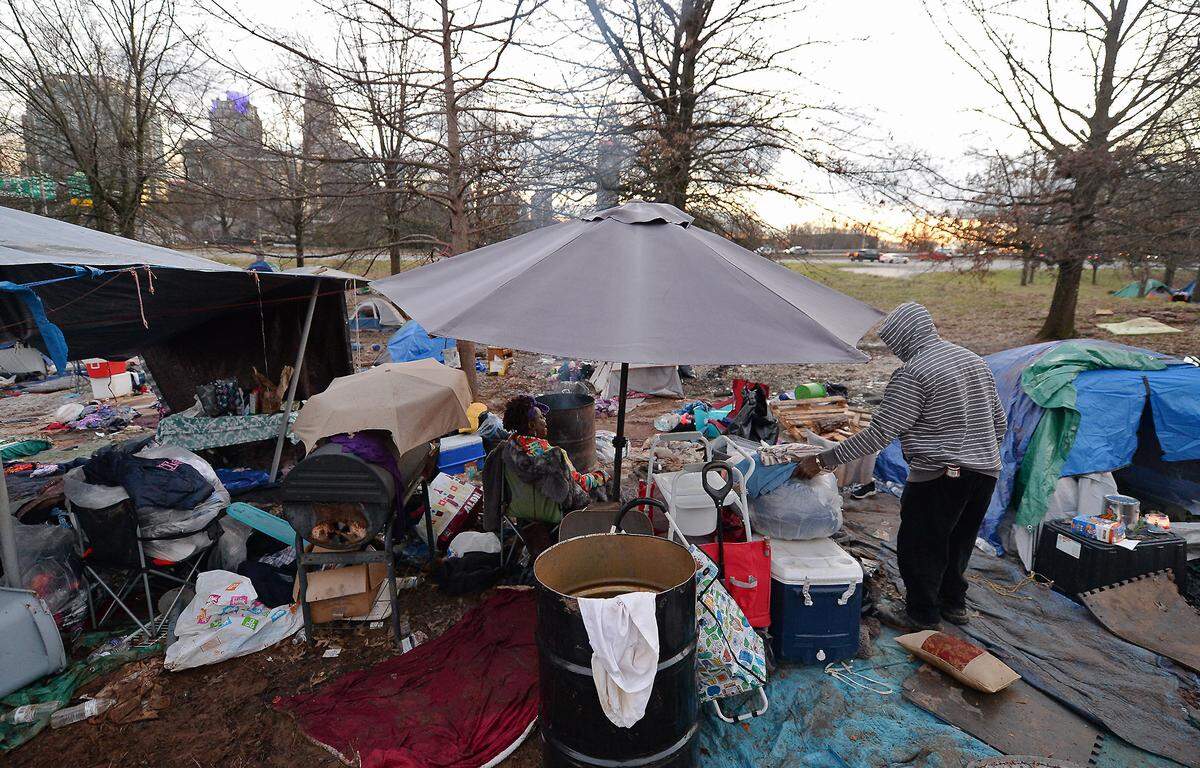 A woman, left, takes a break from moving her personal belongings as a companion, right, moves a few items to be taken from the homeless encampment near Graham Street in Charlotte, NC on Friday, February 19, 2021. Residents of tent encampment were required to vacate the area after health risks from rodent infestation were found in the area.