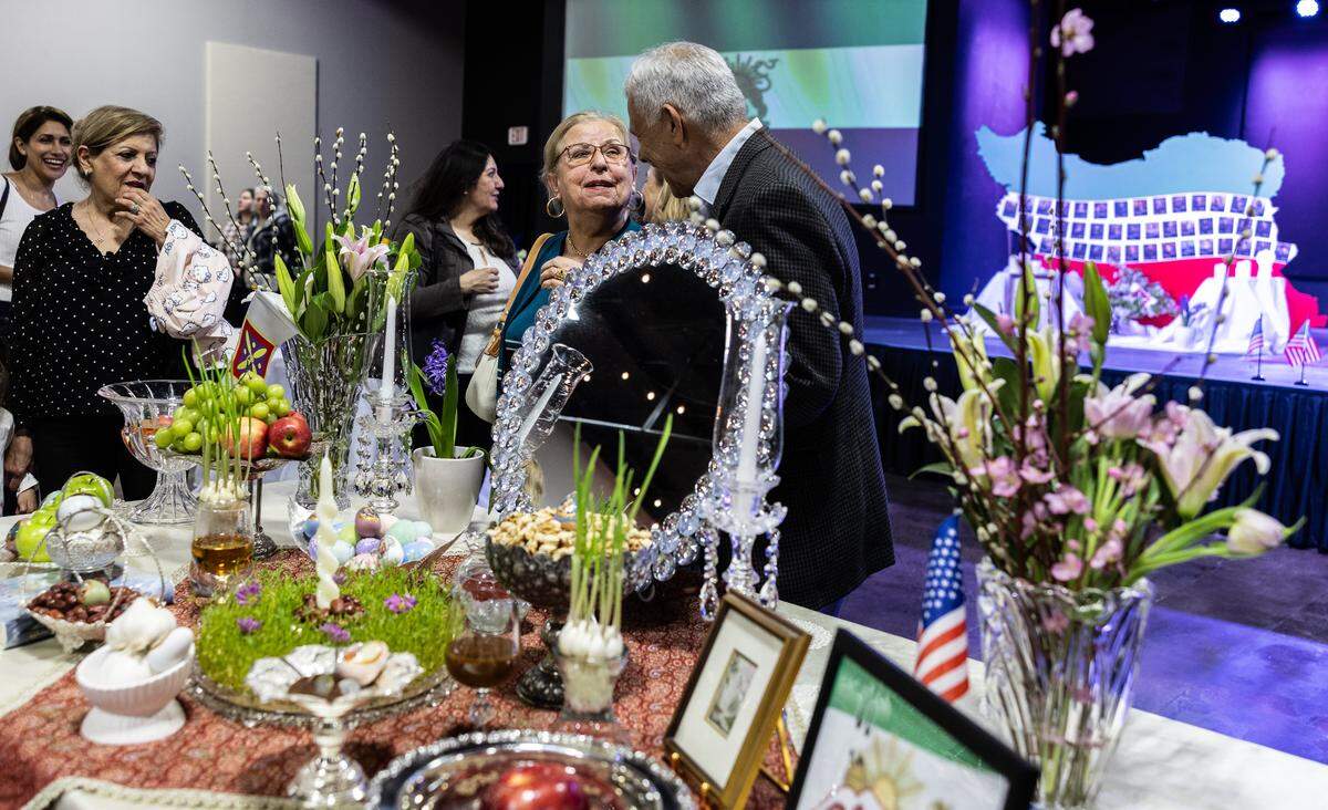 People gather around the “Haft-Sin” table representing the seven items displayed during Nowruz at the Nowruz Bazaar in Charlotte.