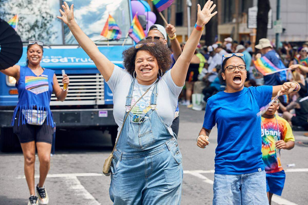 U.S. Bank members cheer on as they make their way down the parade route during the 25th Charlotte Pride Parade in uptown Charlotte on August 17, 2025.