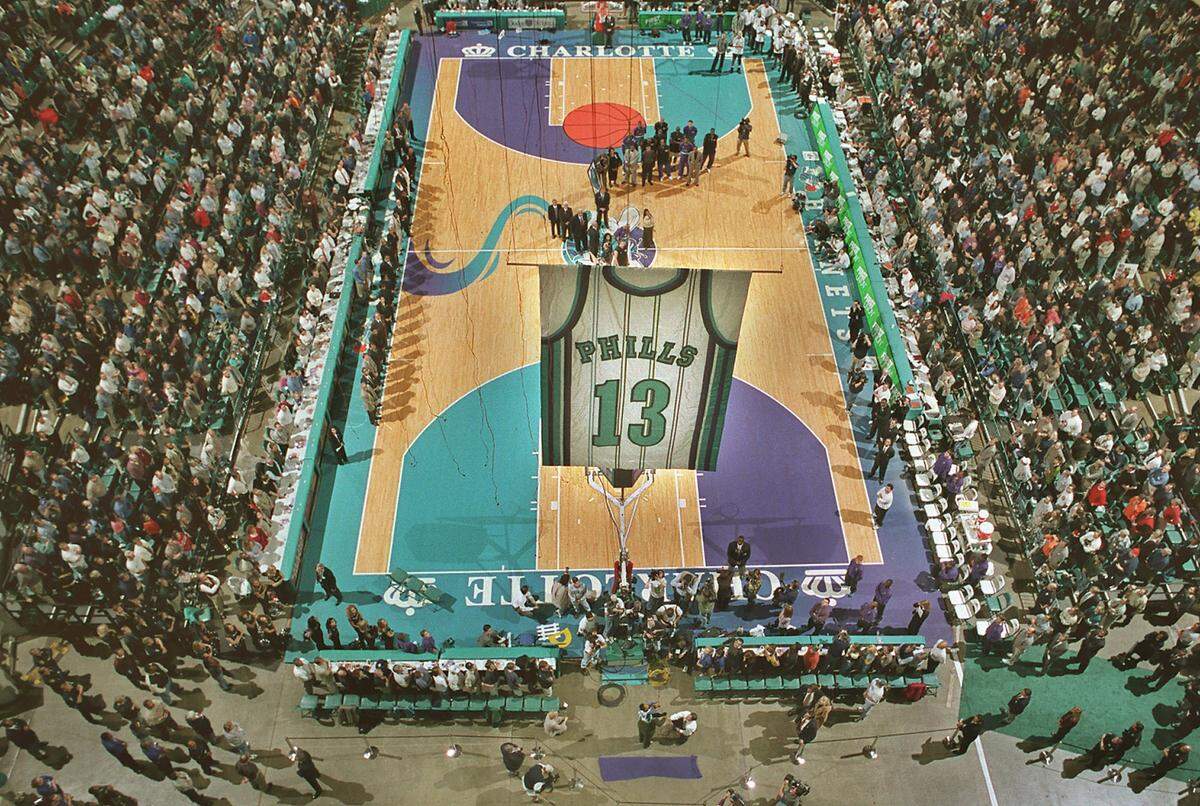 Dwayne Phills raises his brother Bobby's jersey with help from Bobby Phills' son Trey, 3, as the Charlotte Hornets retire the number during a ceremony at the old Charlotte Coliseum on Feb. 8, 2000. Bobby Phills had been killed in a car crash one month before.