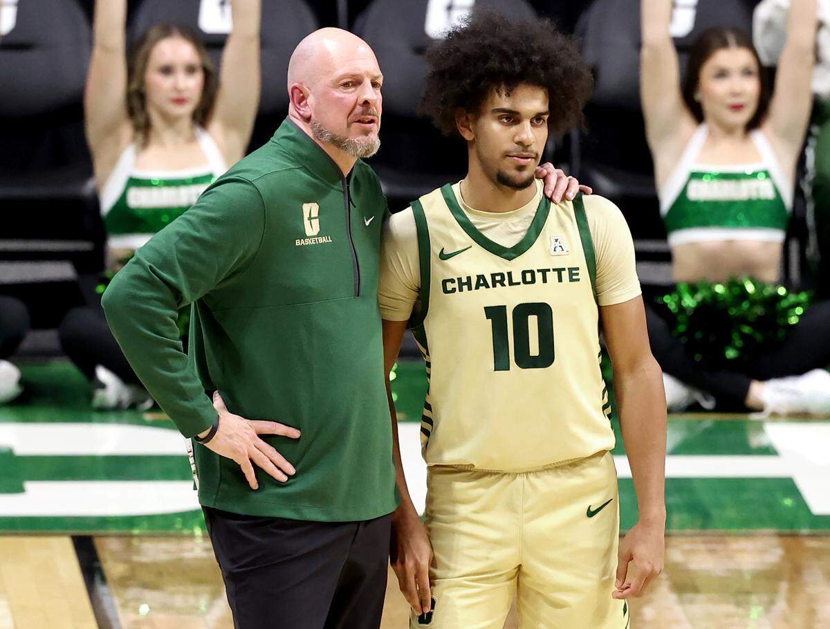 Charlotte 49ers head coach Aaron Fearne, left, talks to guard Nik Graves, right, during action against Florida Atlantic University on Wednesday, January 8, 2025 at Halton Arena on the campus of UNC Charlotte in Charlotte, NC.