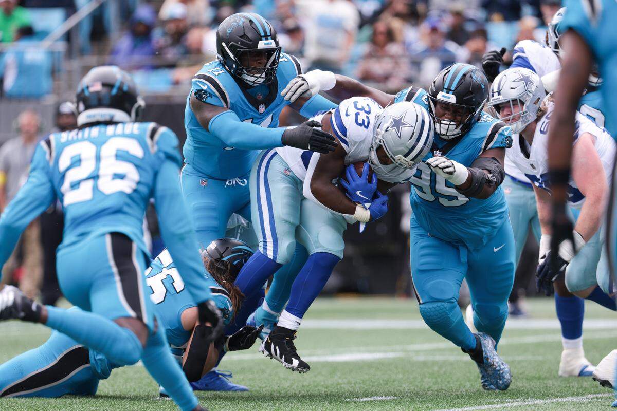 Oct 12, 2025; Charlotte, North Carolina, USA; Carolina Panthers linebacker Nic Scourton (11) and defensive end Derrick Brown (95) tackle Dallas Cowboys running back Javonte Williams (33) short of the goal line during the first quarter at Bank of America Stadium. Mandatory Credit: Scott Kinser-Imagn Images