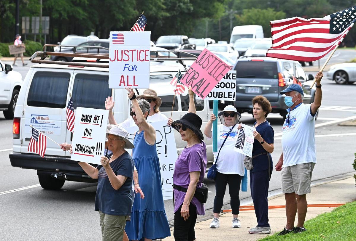Indivisible Charlotte supporters stand along Hwy 51 and Providence Road on Thursday, July 17, 2025. The group along with hundreds of communities across the country are coming together to honor the legacy of Congressman John Lewis with “Good Trouble Lives On” Day of Action demonstrations.
