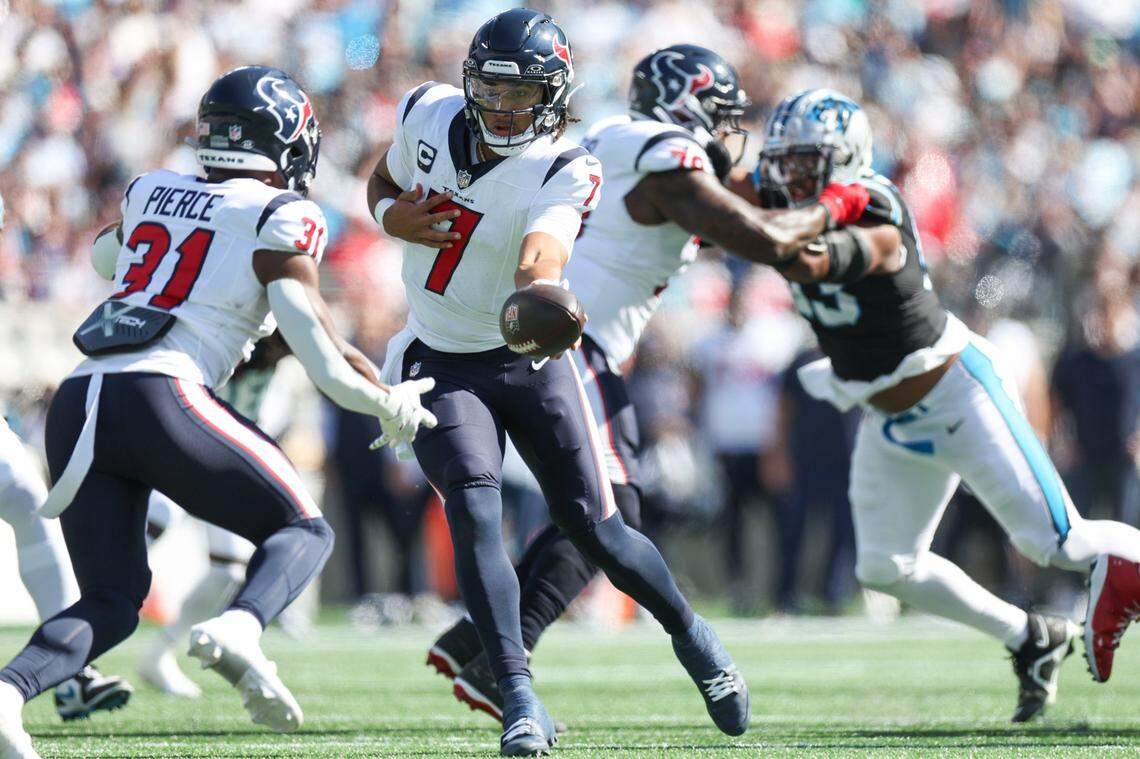 Houston Texans quarterback C.J. Stroud, center, hans the ball off to Houston Texans running back Dameon Pierce, left, during the game at Bank of America Stadium on Sunday, October 29, 2023.