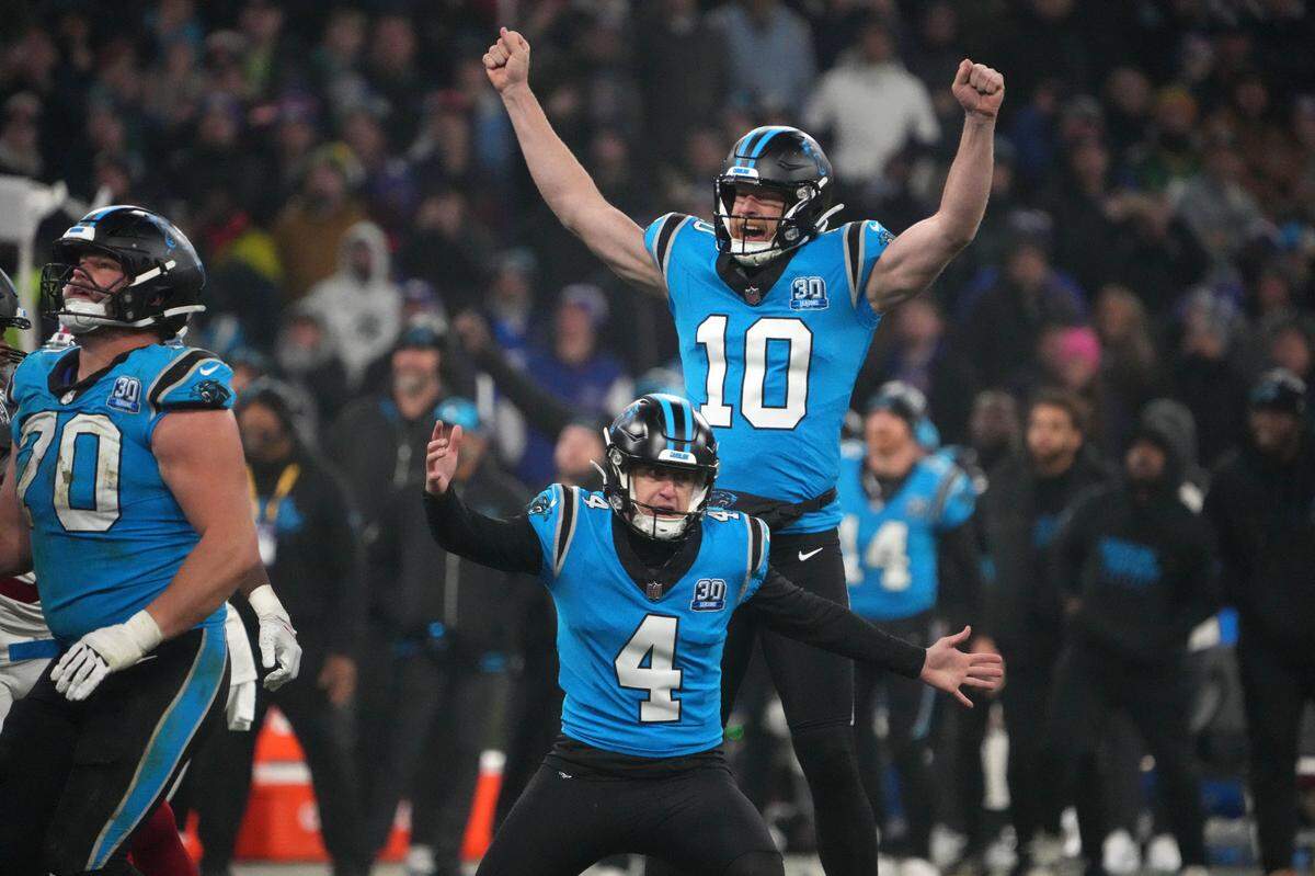 Carolina Panthers place kicker Eddy Pineiro (4) celebrates with punter Johnny Hekker (10) after kicking a 36-yard field goal in overtime against the New York Giants during Sunday’s 2024 NFL Munich Game at Allianz Arena.