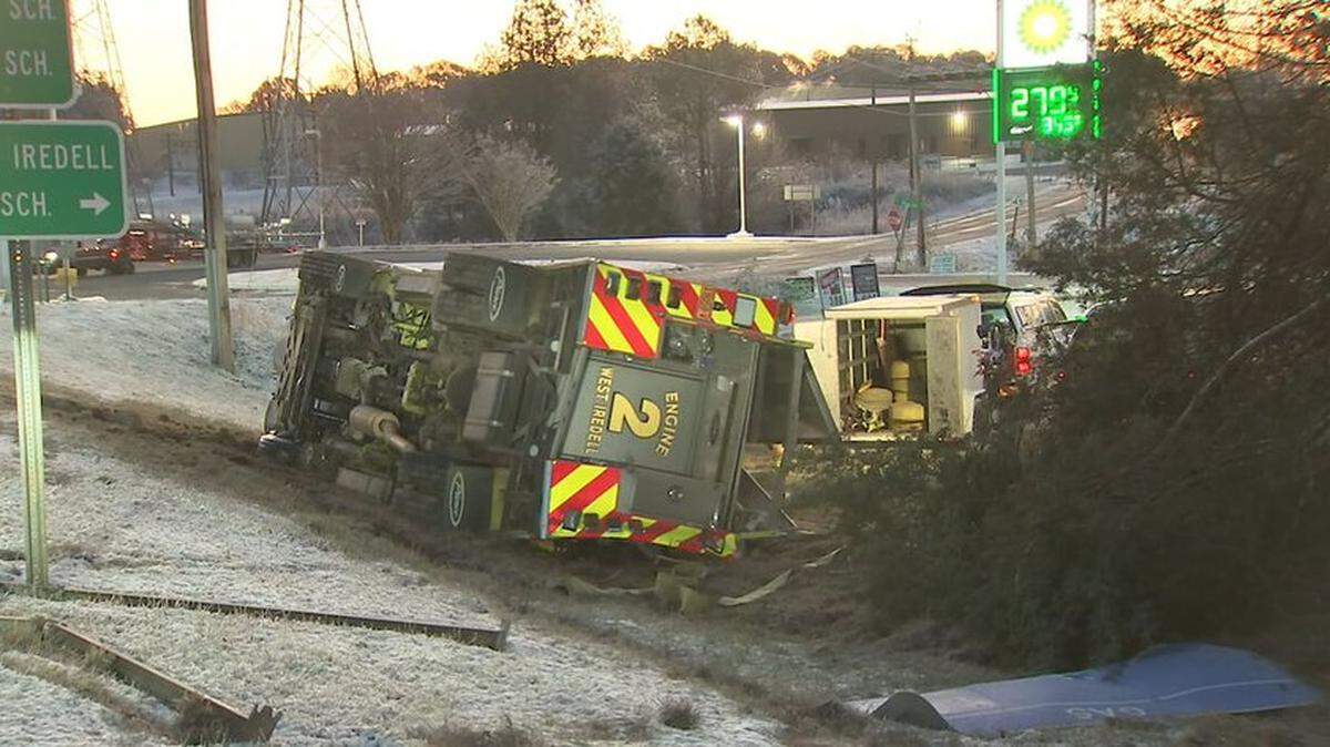 A firefighter was hospitalized early Tuesday after his West Iredell Fire Department truck overturned in wintry weather while responding to wrecks, Charlotte Observer news partner WSOC reported.